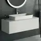 Waschtisch mit ovalem Becken und Chromarmatur, montiert an einer schlichten weißen Wand. Ideal Standard bietet eine klare, moderne Designlösung für Badezimmer.